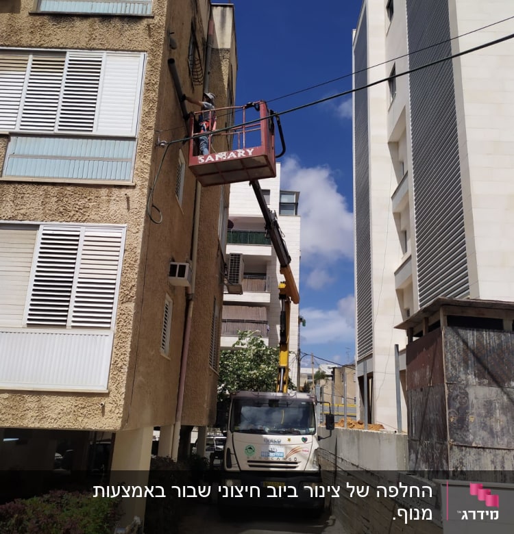 אדם על מנוף ליד בניין, צינור חשוף